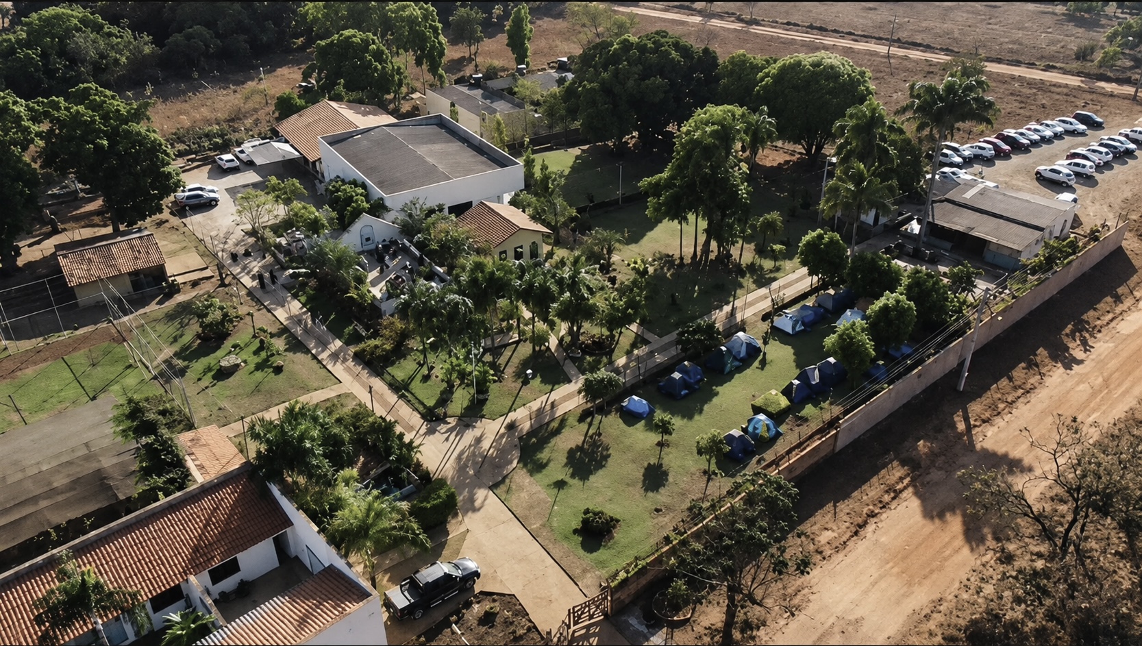 Vista aérea geral da Casa de Retiro com pátio, capela e área de camping